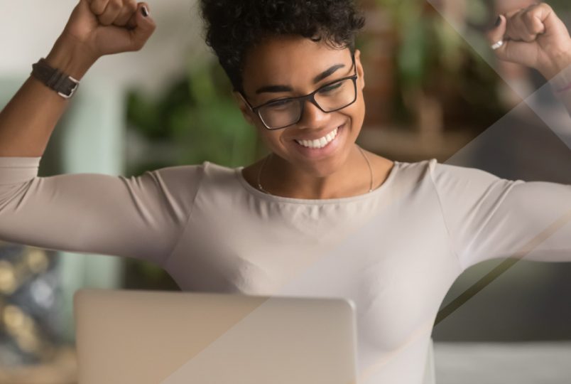 A woman at a desk celebrates the arrival of Joiin's multi-dimensional reporting feature